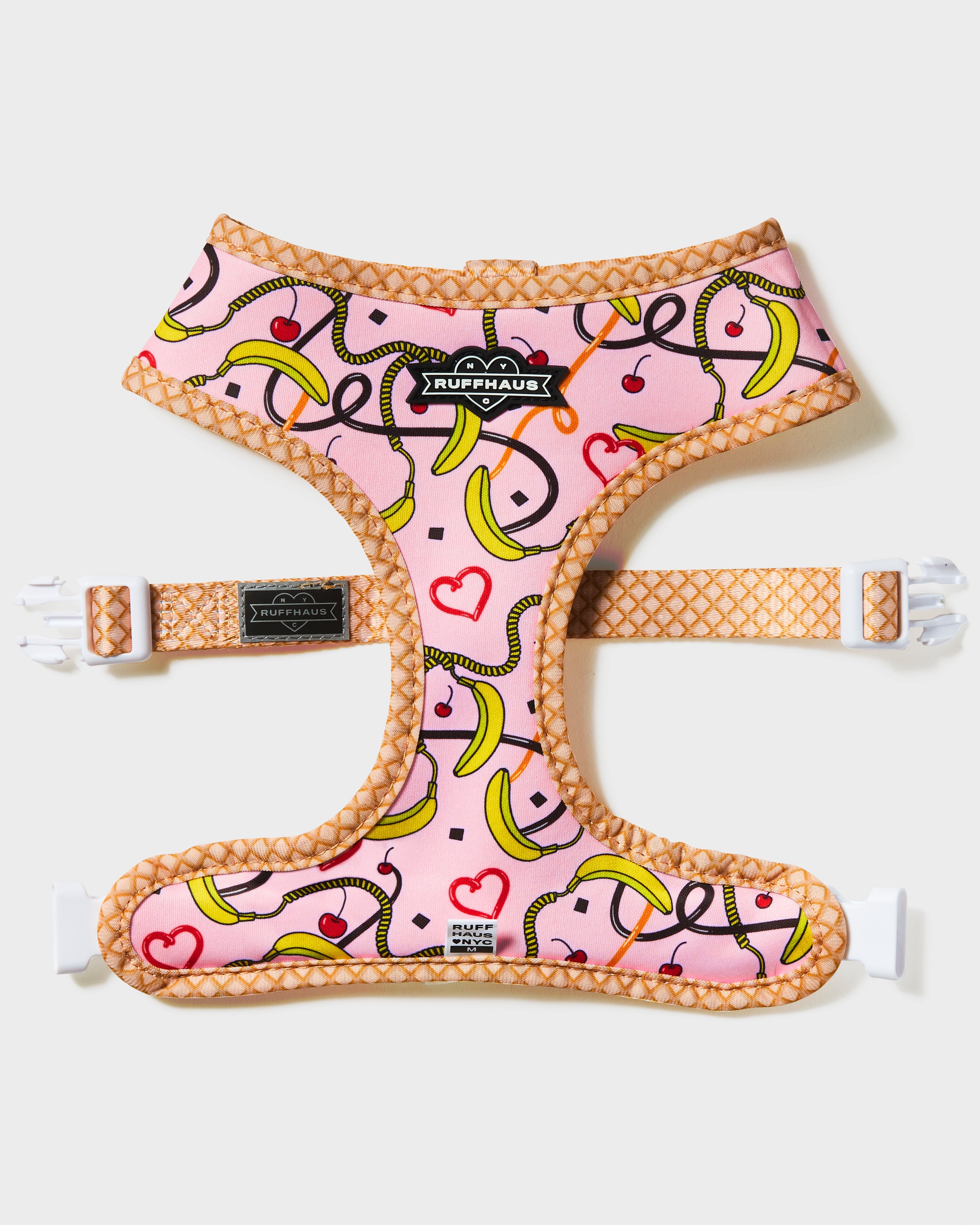 Reversible pink harness for pets by RUFFHAUS NYC, showing both sides with adjustable straps and metal D-ring for leash attachment.