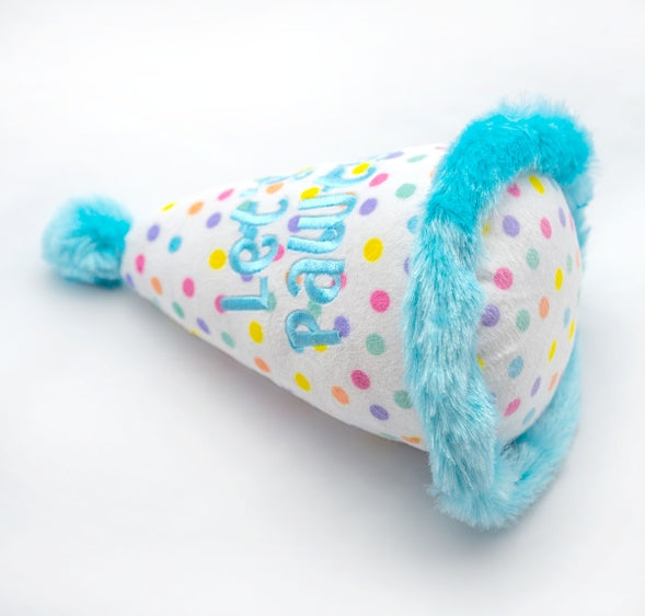 Blue plush birthday hat toy for dogs by Luna Doodle Boutique, featuring soft fabric and festive design.
